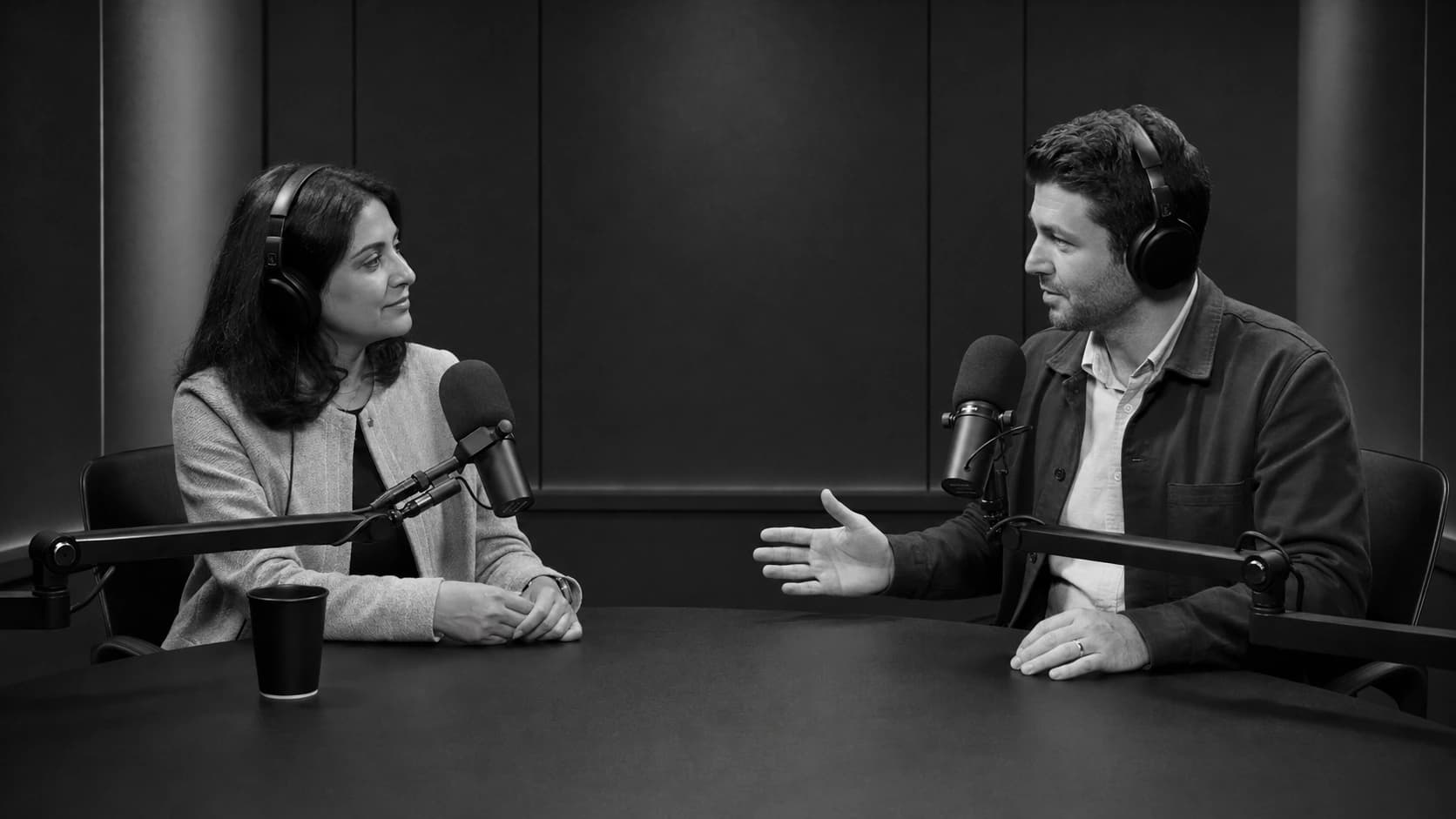 Two policy researchers discussing legislation in a podcast studio